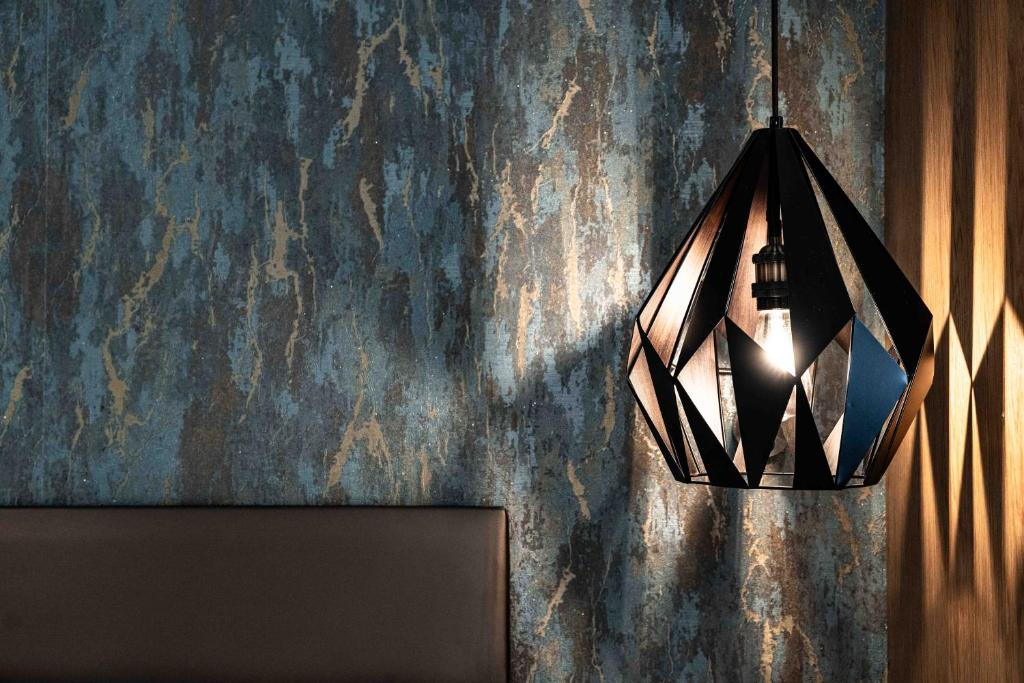 Elegant interior detail at The Jade - geometric pendant lamp against textured wall